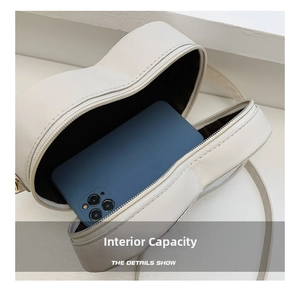 Détail montrant la capacité interne du sac blanc en forme de cœur avec un smartphone