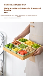 Close-up of hand holding a 9-compartment ceramic snack tray with bamboo wooden base