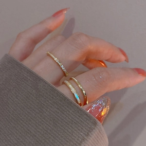 Detail of layered gold rings with cubic zirconia and white mother-of-pearl on a hand