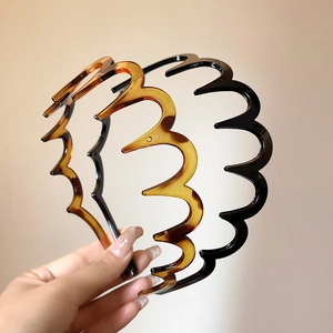Detail view of wavy non-slip headbands in tortoiseshell and black resin finish