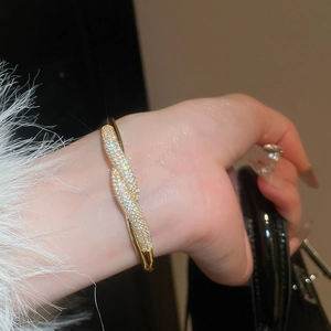 Gros plan d'un bracelet jonc noué plaqué or 18 carats avec oxydes de zirconium pavés