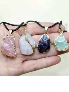 Vue macro de pendentifs en pierres naturelles irrégulières avec bordure dorée et cristaux