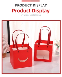Macro detail of red paper gift bags with smiley cut-outs and elegant ribbon handles