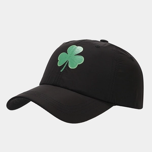 Detail of a breathable black baseball cap with green clover print and side stitching
