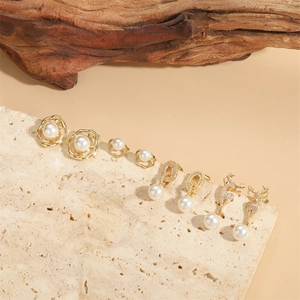 Elegant gold pearl earring set featuring deer motifs and zircon accents on travertine