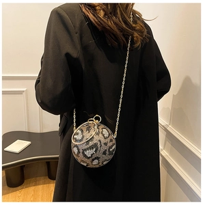 Fashionable leopard print spherical evening bag with gold chain worn by a model in a suit