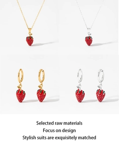 Detail view of strawberry jewelry set featuring red pendants in gold and silver finish