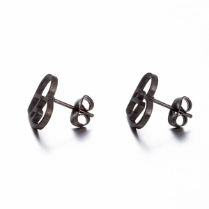 Detailed view of dark metal B-shaped stud earrings with a brushed matte finish