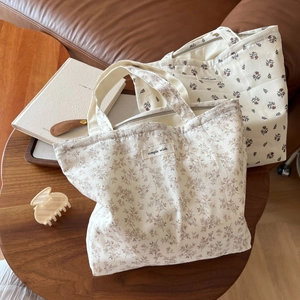 Nahaufnahme der floralen Baumwolltaschen mit Simple Wish Label auf rustikalem Holztisch