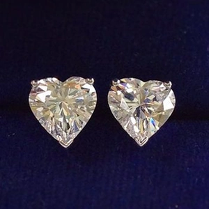 Macro shot of elegant heart-shaped white zircon earrings with silver claw settings