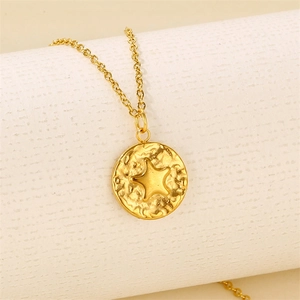 Golden titanium steel coin necklace with star relief and hammered texture on beige background