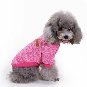 Close-up of pink knit dog sweater showing ribbed texture and classic leather patch