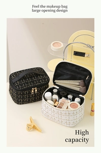 Detail of tweed makeup bag showing large opening design and gold checkered pattern