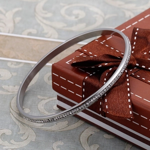Elegante bracciale rigido argento in acciaio inox con diamanti su una scatola regalo
