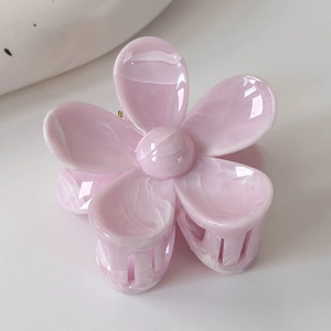Détail de la pince à cheveux fleur rose marbrée avec une texture lisse en acétate