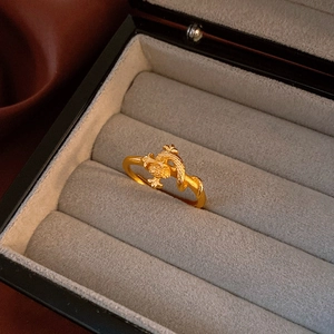 Macro detail of vintage golden dragon ring with matte finish in a grey jewelry box