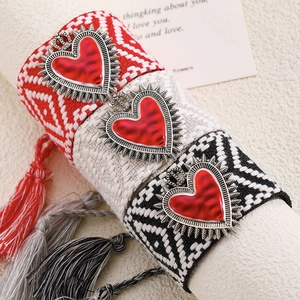 Detailed macro of Bohemian woven heart pendant necklaces with vibrant cotton tassels