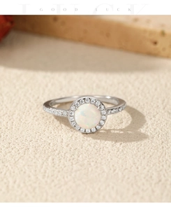 Macro view of S925 sterling silver ring with opal center stone and halo diamonds