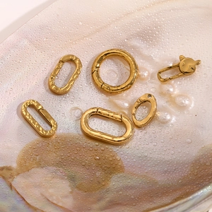 Macro shot of gold-plated geometric fasteners and cat buckles on pearlescent surface