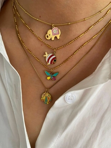 Detail of layered gold necklaces featuring colorful enamel elephant and butterfly pendants