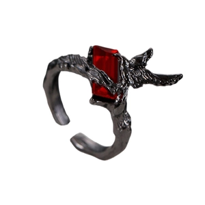Macro detail of gothic thorn ring with black metal texture and red rectangular gemstone