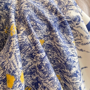 Close-up of winter cashmere scarf featuring artistic daisy prints and twill texture