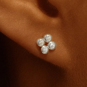 Detail view of S925 silver ear stud with four clear zircon stones on ear cartilage