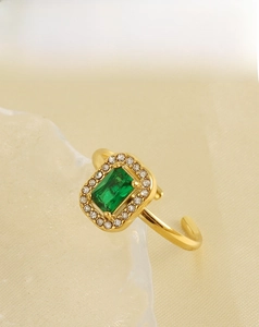 Detail of 18k gold plated ring featuring a green square gemstone and white zircon accents
