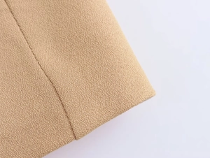 Macro shot of khaki woven fabric showing premium textured fibers and detailed stitching