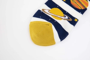 Detail of yellow knit toe with blue space-themed planet patterns on cotton crew socks