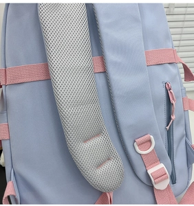 Detail of breathable grey mesh padding and pink shoulder straps on light blue backpack