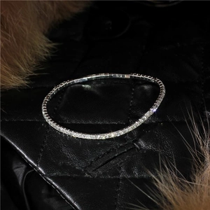 Detail of 2.0mm silver-toned single row rhinestone bracelet on black quilted leather
