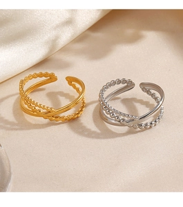 Close-up of gold and silver layered open rings with bead texture on silk background