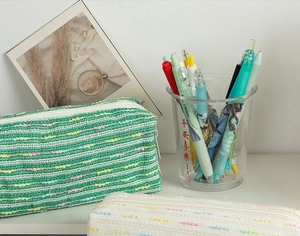 Detailed view of woven pencil case with colorful polka dots and smooth zipper closure