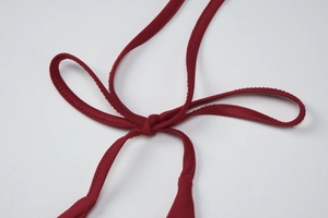 Detailed close-up of dark red tie-up strap and high-elastic knit fabric texture