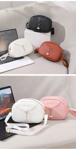 Detail of chevron quilted crossbody bag featuring pearl pendant and gold hardware