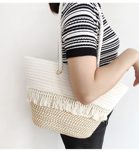 Detailed shot of bohemian woven cotton rope tote bag with fringe tassels and metal rings