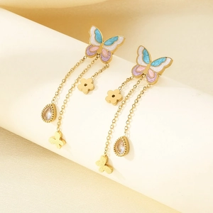 Detail of butterfly tassel earrings with pink oil drip wings and gold chain drops