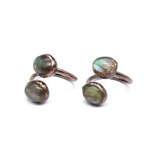 Detail view of two antique bronze open rings with oval iridescent labradorite stones