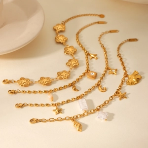 Detailed view of four gold-plated stainless steel bracelets with celestial and floral charms