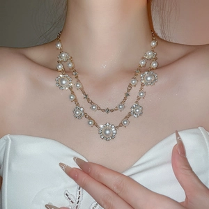 Close-up of double-layer pearl necklace with sparkling rhinestones on model neck