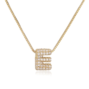 Macro shot of gold-plated bubble letter E pendant necklace with sparkling zircon pavé
