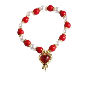 Handgefertigtes Perlenarmband mit roten Glasperlen und goldenem Herzanhänger