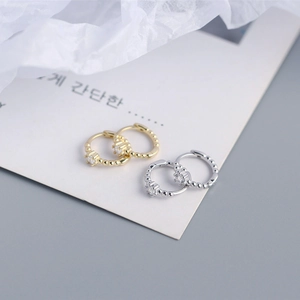 Close-up of beaded S925 sterling silver hoop earrings with sparkling cubic zirconia