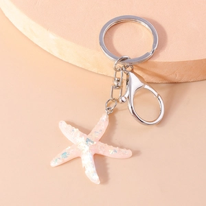 Detailed view of pink glittery starfish keychain with silver metal lobster clasp and ring