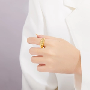 Detailed view of a gold croissant dome ring worn on a finger for a chic vintage style