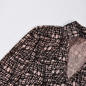Detail of high neck and V-cut collar with abstract print on pink mesh fabric