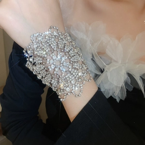Nahaufnahme eines funkelnden Strass-Blumenarmbands mit elegantem Spitzenmuster am Handgelenk