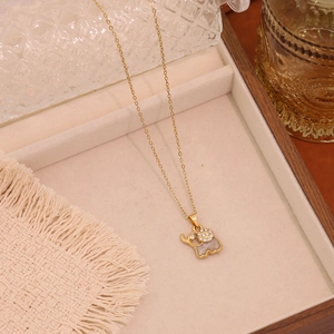 Detailed view of a gold elephant pendant necklace with sparkling rhinestones and grey enamel