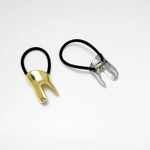 Close-up of gold and silver U-shaped metal cuffs on thick minimalist hair ties